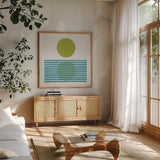 Reflection I Green by Moira Hershey. Shown in a natural wood frame in a cozy modern living room. Available as an archival giclee rolled canvas, fine art paper, or poster print. SKU 72250a.