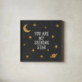 Shining Star Black 6x6 by Moira Hershey. Shown in a sleek black glass frame for a contemporary gallery look. Available as an archival giclee rolled canvas, fine art paper, or poster print. SKU 17151a.