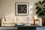 To the Moon Black by Moira Hershey. Displayed in a glass frame with matte in a clean modern living room. Available as an archival giclee rolled canvas, fine art paper, or poster print. SKU 17152a.