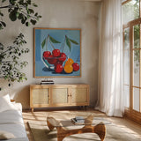 Bowl of Cherries by Morgan Birch. Shown in a natural wood frame in a cozy modern living room. Available as an archival giclee rolled canvas, fine art paper, or poster print. SKU 103543a.