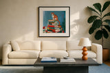 Cat on Book Stack by Morgan Birch. Displayed in a glass frame with matte in a clean modern living room. Available as an archival giclee rolled canvas, fine art paper, or poster print. SKU 103140a.