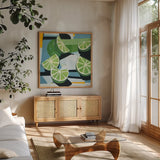 Fresh Cut Limes by Morgan Birch. Shown in a natural wood frame in a cozy modern living room. Available as an archival giclee rolled canvas, fine art paper, or poster print. SKU 104055a.