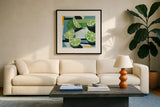 Fresh Cut Limes by Morgan Birch. Displayed in a glass frame with matte in a clean modern living room. Available as an archival giclee rolled canvas, fine art paper, or poster print. SKU 104055a.
