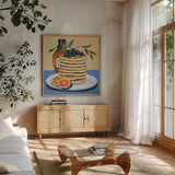 Pancake Day by Morgan Birch. Shown in a natural wood frame in a cozy modern living room. Available as an archival giclee rolled canvas, fine art paper, or poster print. SKU 104010a.