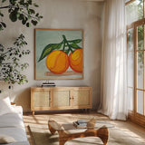 Two Oranges by Morgan Birch. Shown in a natural wood frame in a cozy modern living room. Available as an archival giclee rolled canvas, fine art paper, or poster print. SKU 104056a.