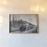 Alaskan Train by Nathan Larson. shown as a paper print in a natural frame. Available as a archival giclee rolled canvas, fine art paper, or poster print. SKU 94125i.