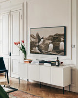 Atlantic Puffin Colony by Nathan Larson. shown as a framed stretched canvas in a living room above a console. Available as a archival giclee rolled canvas, fine art paper, or poster print. SKU 100609i.