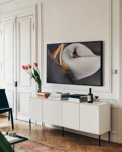 Atlantic Puffin Tucked by Nathan Larson. shown as a framed stretched canvas in a living room above a console. Available as a archival giclee rolled canvas, fine art paper, or poster print. SKU 100611i.