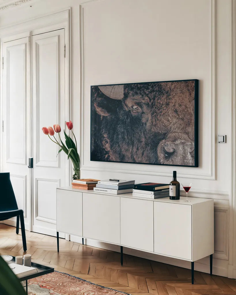 Bison Stare by Nathan Larson. shown as a framed stretched canvas in a living room above a console. Available as a archival giclee rolled canvas, fine art paper, or poster print. SKU 87947i.