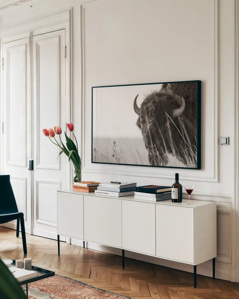 Bison Sunset BW by Nathan Larson. shown as a framed stretched canvas in a living room above a console. Available as a archival giclee rolled canvas, fine art paper, or poster print. SKU 98334i.
