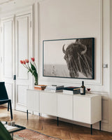 Bison Sunset BW by Nathan Larson. shown as a framed stretched canvas in a living room above a console. Available as a archival giclee rolled canvas, fine art paper, or poster print. SKU 98334i.