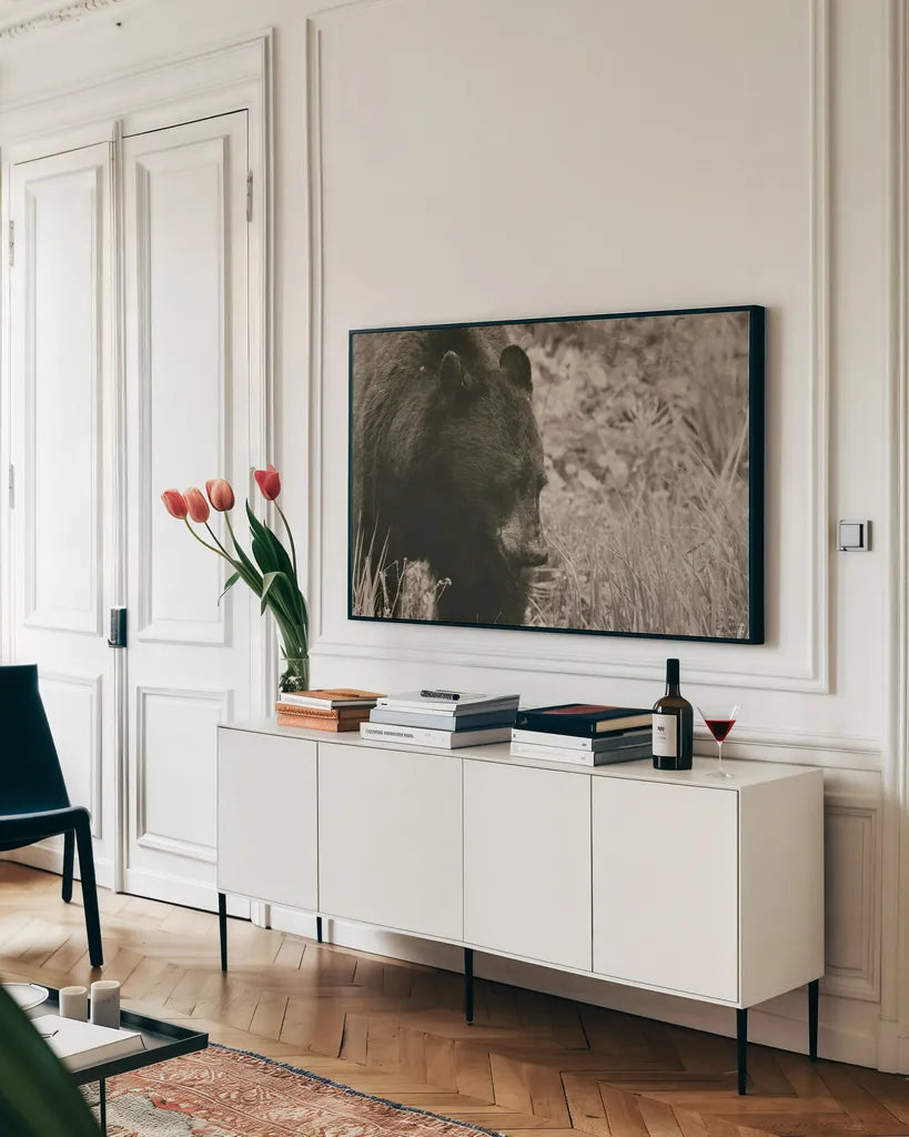 Black Bear Wander by Nathan Larson. shown as a framed stretched canvas in a living room above a console. Available as a archival giclee rolled canvas, fine art paper, or poster print. SKU 100753i.