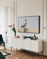 Brown Pelican by Nathan Larson. shown as a framed stretched canvas in a living room above a console. Available as a archival giclee rolled canvas, fine art paper, or poster print. SKU 104265i.