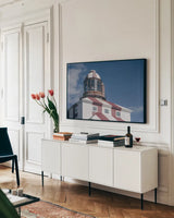 Cape Bona Vista Lighthouse II by Nathan Larson. shown as a framed stretched canvas in a living room above a console. Available as a archival giclee rolled canvas, fine art paper, or poster print. SKU 103220i.