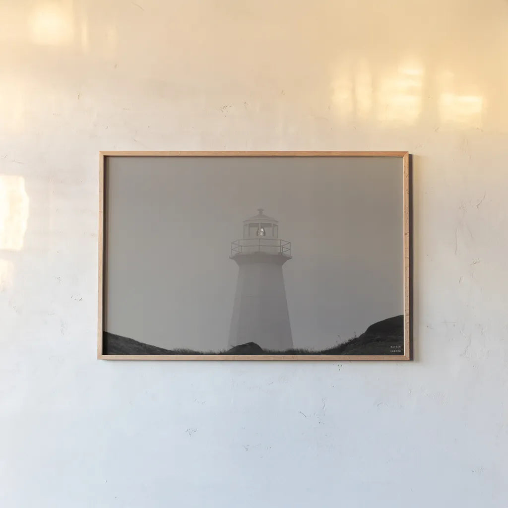 Cape Spear Lighthouse by Nathan Larson. shown as a paper print in a natural frame. Available as a archival giclee rolled canvas, fine art paper, or poster print. SKU 100500i.