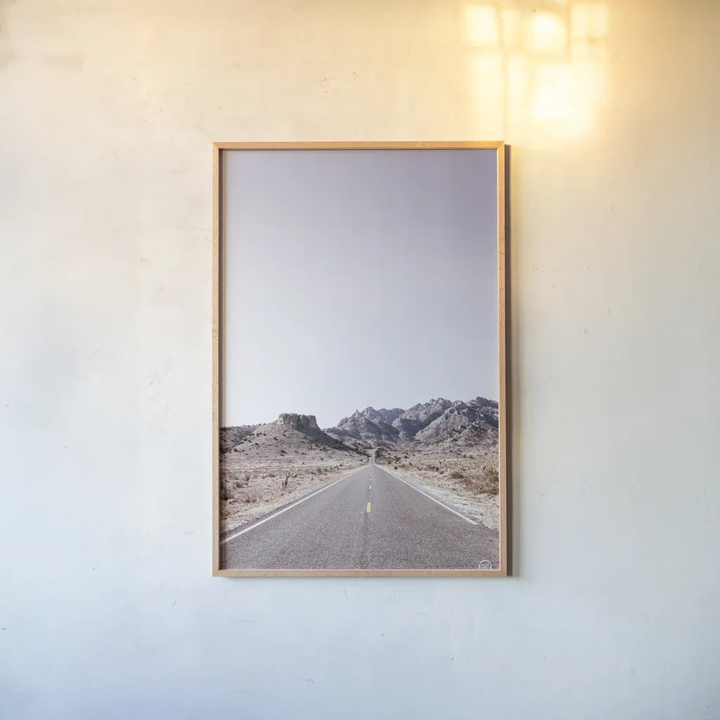 Dusty Desert Dreams Road by Nathan Larson. shown as a paper print in a natural frame. Available as a archival giclee rolled canvas, fine art paper, or poster print. SKU 72031h.
