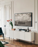 Grand Teton Settlers by Nathan Larson. shown as a framed stretched canvas in a living room above a console. Available as a archival giclee rolled canvas, fine art paper, or poster print. SKU 92473i.