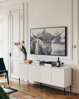 Highland Cow Pastures II by Nathan Larson. shown as a framed stretched canvas in a living room above a console. Available as a archival giclee rolled canvas, fine art paper, or poster print. SKU 90698i.