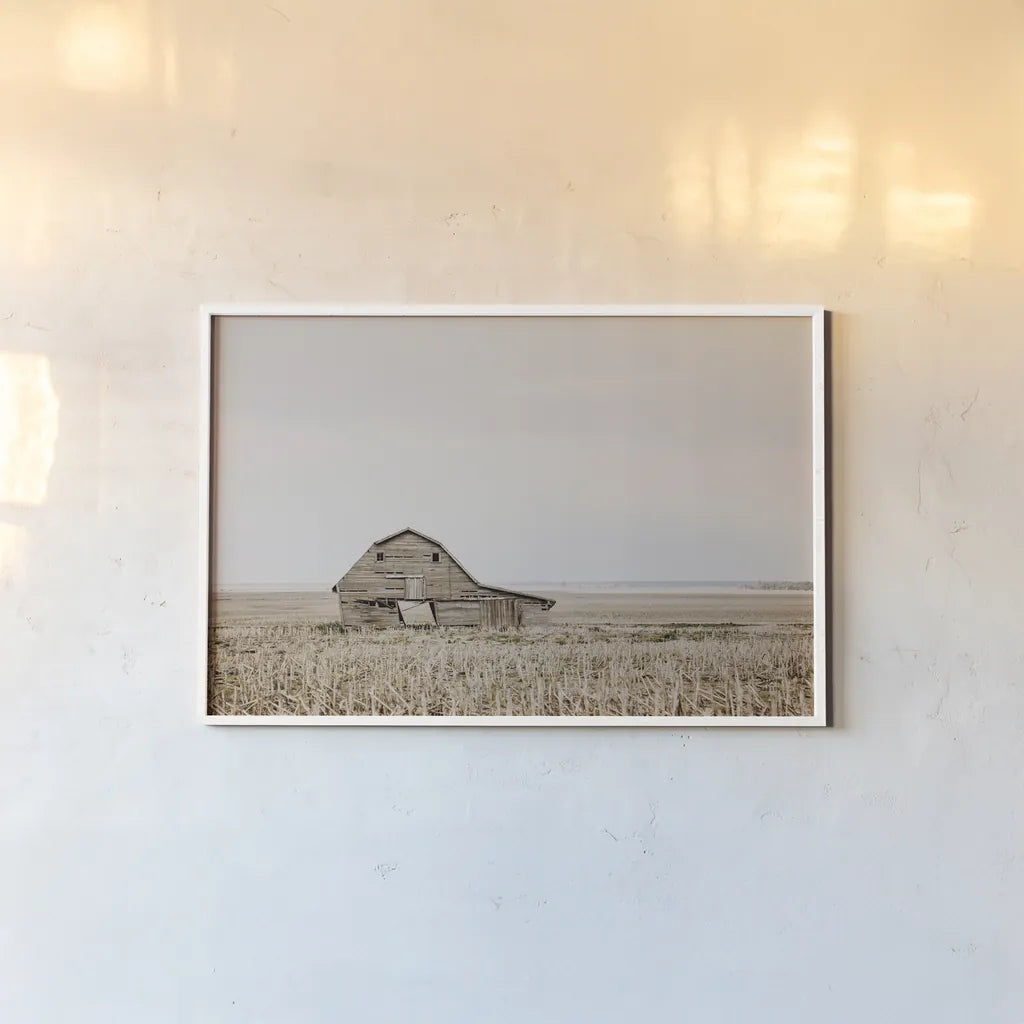 Leaning Barn by Nathan Larson. shown as a paper print in a white frame. Available as a archival giclee rolled canvas, fine art paper, or poster print. SKU 86062i.