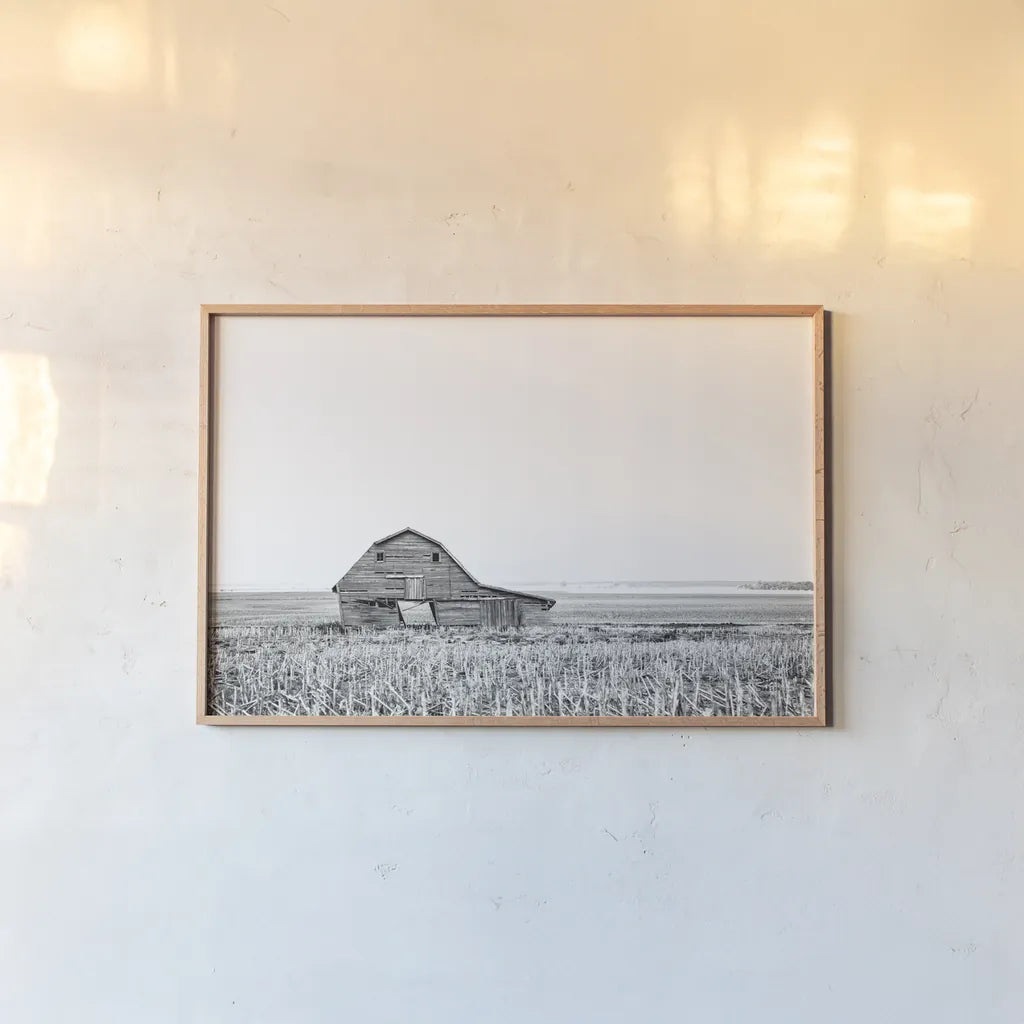 Leaning Barn BW by Nathan Larson. shown as a paper print in a natural frame. Available as a archival giclee rolled canvas, fine art paper, or poster print. SKU 86064i.