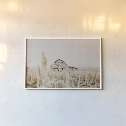 Leaning Barn Field I by Nathan Larson. shown as a paper print in a white frame. Available as a archival giclee rolled canvas, fine art paper, or poster print. SKU 86060i.