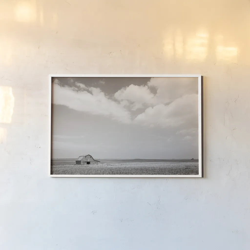 Leaning Barn Field III by Nathan Larson. shown as a paper print in a white frame. Available as a archival giclee rolled canvas, fine art paper, or poster print. SKU 86073i.