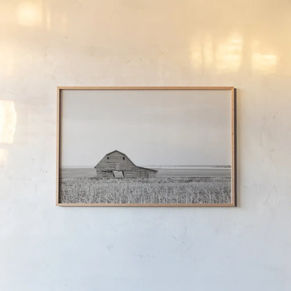 Leaning Barn Neutral by Nathan Larson. shown as a paper print in a natural frame. Available as a archival giclee rolled canvas, fine art paper, or poster print. SKU 86063i.