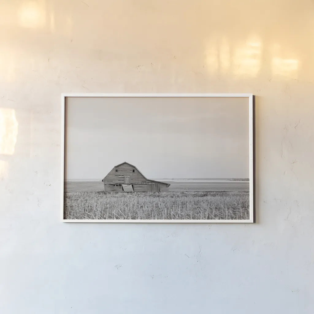 Leaning Barn Neutral by Nathan Larson. shown as a paper print in a white frame. Available as a archival giclee rolled canvas, fine art paper, or poster print. SKU 86063i.