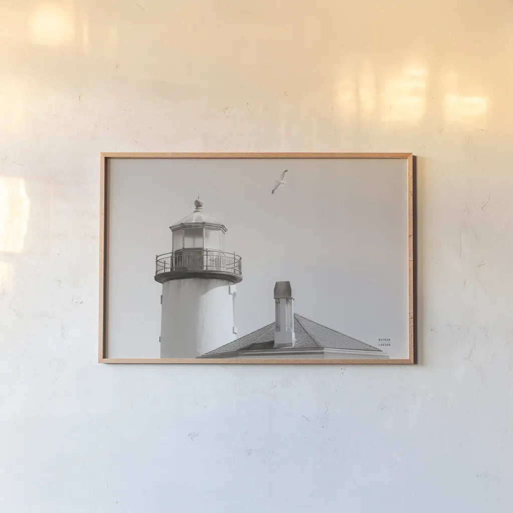 Lighthouse Fly Over by Nathan Larson. shown as a paper print in a natural frame. Available as a archival giclee rolled canvas, fine art paper, or poster print. SKU 87193i.