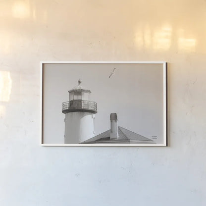 Lighthouse Fly Over by Nathan Larson. shown as a paper print in a white frame. Available as a archival giclee rolled canvas, fine art paper, or poster print. SKU 87193i.