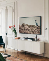 Little Blue Heron Hunting by Nathan Larson. shown as a framed stretched canvas in a living room above a console. Available as a archival giclee rolled canvas, fine art paper, or poster print. SKU 97885i.