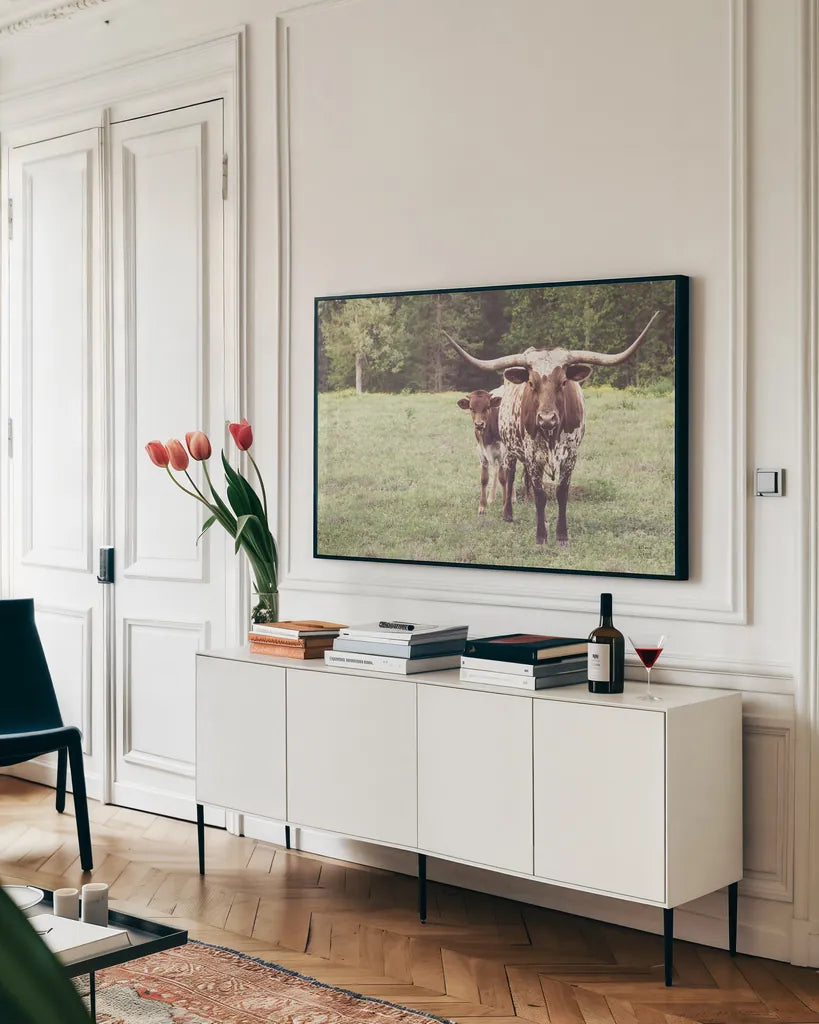 Longhorn Protection by Nathan Larson. shown as a framed stretched canvas in a living room above a console. Available as a archival giclee rolled canvas, fine art paper, or poster print. SKU 91520i.