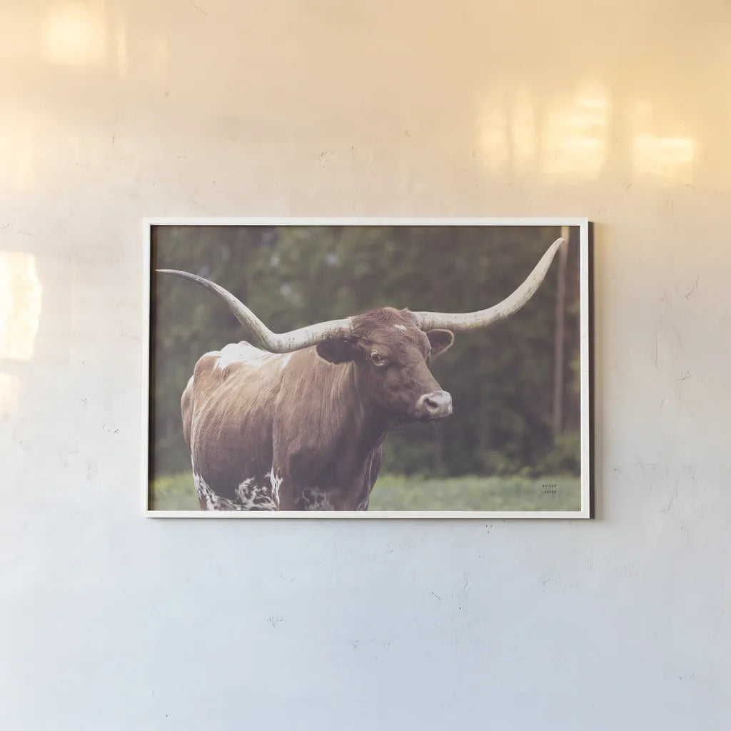 Longhorn Side Eye by Nathan Larson. shown as a paper print in a white frame. Available as a archival giclee rolled canvas, fine art paper, or poster print. SKU 93360i.