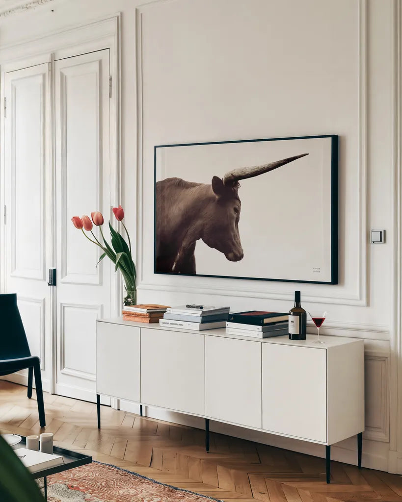 Longhorn Sunset Graze Sepia by Nathan Larson. shown as a framed stretched canvas in a living room above a console. Available as a archival giclee rolled canvas, fine art paper, or poster print. SKU 92289i.