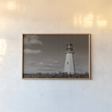 Low Point Lighthouse by Nathan Larson. shown as a paper print in a natural frame. Available as a archival giclee rolled canvas, fine art paper, or poster print. SKU 100499i.