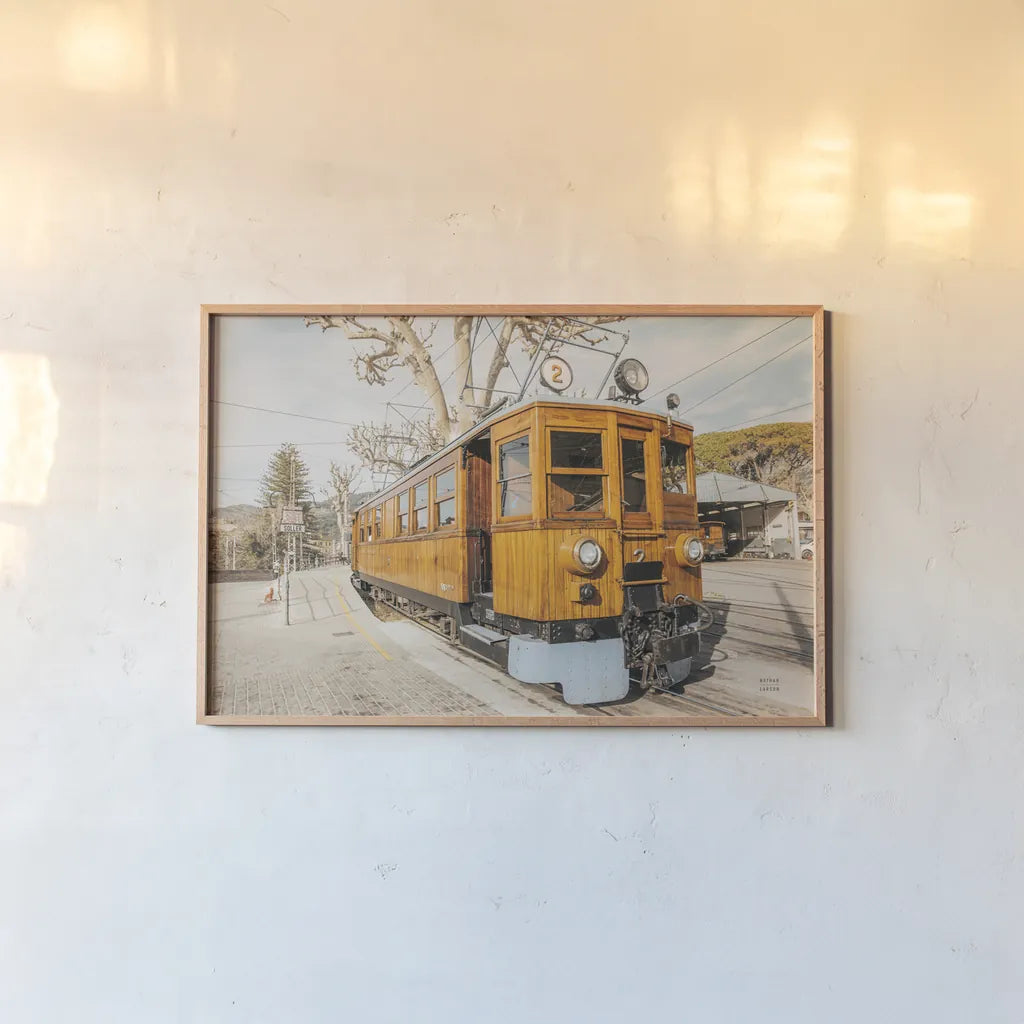 Mallorca Train by Nathan Larson. shown as a paper print in a natural frame. Available as a archival giclee rolled canvas, fine art paper, or poster print. SKU 85801i.