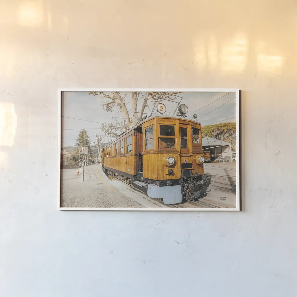 Mallorca Train by Nathan Larson. shown as a paper print in a white frame. Available as a archival giclee rolled canvas, fine art paper, or poster print. SKU 85801i.