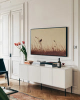 Meadowlark Call Antique by Nathan Larson. shown as a framed stretched canvas in a living room above a console. Available as a archival giclee rolled canvas, fine art paper, or poster print. SKU 98337i.