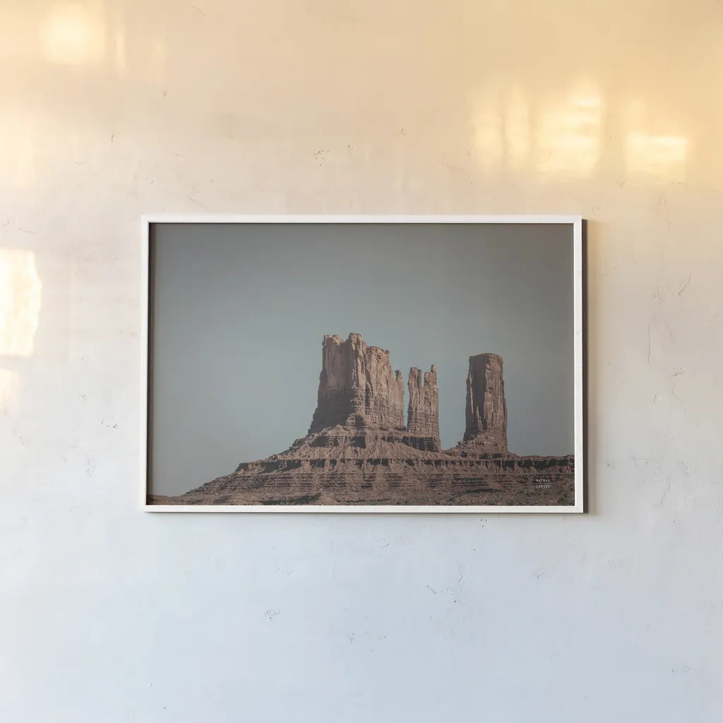 Monument Valley II by Nathan Larson. shown as a paper print in a white frame. Available as a archival giclee rolled canvas, fine art paper, or poster print. SKU 86709i.