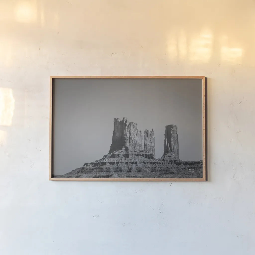 Monument Valley II BW by Nathan Larson. shown as a paper print in a natural frame. Available as a archival giclee rolled canvas, fine art paper, or poster print. SKU 90381i.