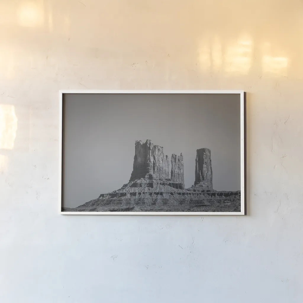 Monument Valley II BW by Nathan Larson. shown as a paper print in a white frame. Available as a archival giclee rolled canvas, fine art paper, or poster print. SKU 90381i.