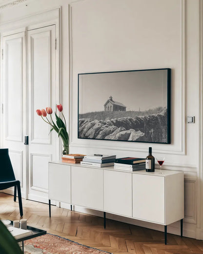 One Room Schoolhouse BW by Nathan Larson. shown as a framed stretched canvas in a living room above a console. Available as a archival giclee rolled canvas, fine art paper, or poster print. SKU 98342i.