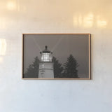 Oregon Coast Lighthouse by Nathan Larson. shown as a paper print in a natural frame. Available as a archival giclee rolled canvas, fine art paper, or poster print. SKU 90172i.