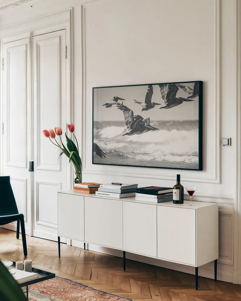 Pelican Beach by Nathan Larson. shown as a framed stretched canvas in a living room above a console. Available as a archival giclee rolled canvas, fine art paper, or poster print. SKU 90480i.