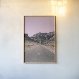 Road to Old West Purple by Nathan Larson. shown as a paper print in a natural frame. Available as a archival giclee rolled canvas, fine art paper, or poster print. SKU 79243h.