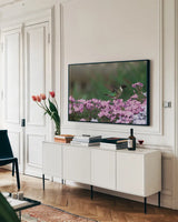 Spring Hummingbird Bright by Nathan Larson. shown as a framed stretched canvas in a living room above a console. Available as a archival giclee rolled canvas, fine art paper, or poster print. SKU 79334i.