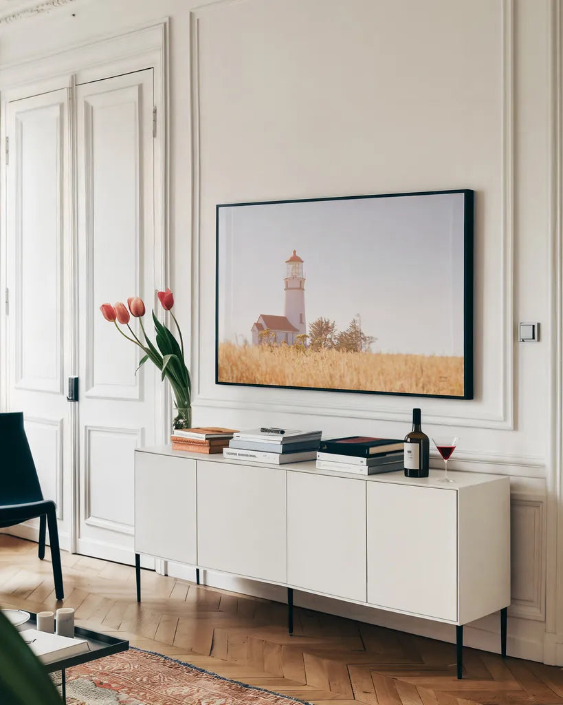 Sunny Day Lighthouse by Nathan Larson. shown as a framed stretched canvas in a living room above a console. Available as a archival giclee rolled canvas, fine art paper, or poster print. SKU 90176i.