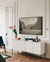 Western Brook Pond Sepia by Nathan Larson. shown as a framed stretched canvas in a living room above a console. Available as a archival giclee rolled canvas, fine art paper, or poster print. SKU 101661i.