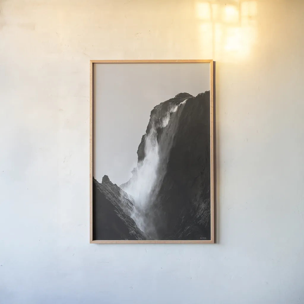 Western Brook Pond Waterfall by Nathan Larson. shown as a paper print in a natural frame. Available as a archival giclee rolled canvas, fine art paper, or poster print. SKU 100501h.