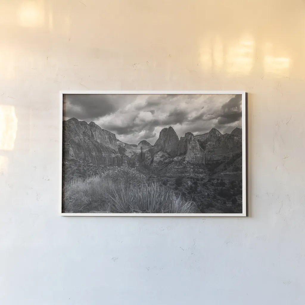 Zion National Park Storms BW by Nathan Larson. shown as a paper print in a white frame. Available as a archival giclee rolled canvas, fine art paper, or poster print. SKU 95630i.